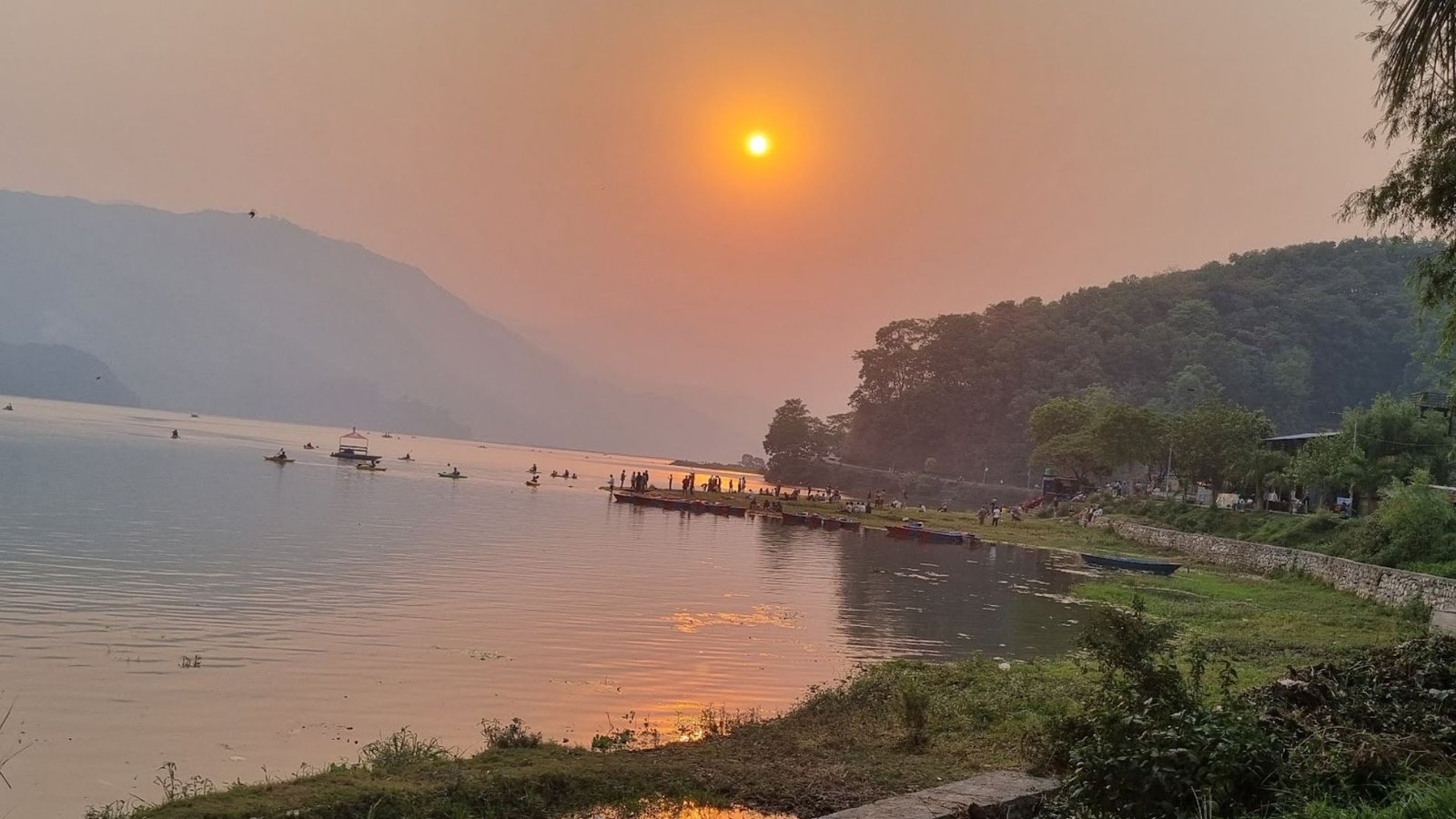 Pôr do sol em Pokhara, Nepal – reflexos dourados sobre o lago e montanhas ao fundo