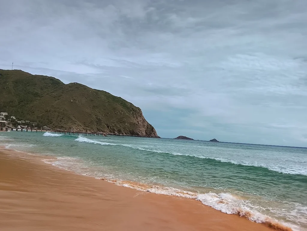 Mar azul-turquesa na ilha de Ky Co, em Quy Nhon, com águas claras e faixa de areia clara no litoral do Vietnã Central.